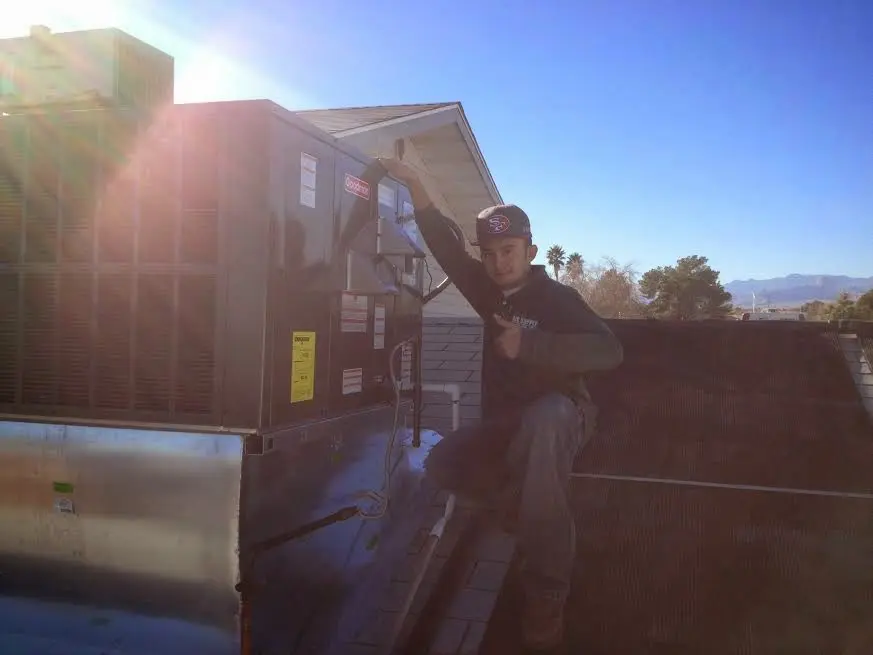 HVAC technician performing HVAC Inspection on a rooftop unit in La Follette